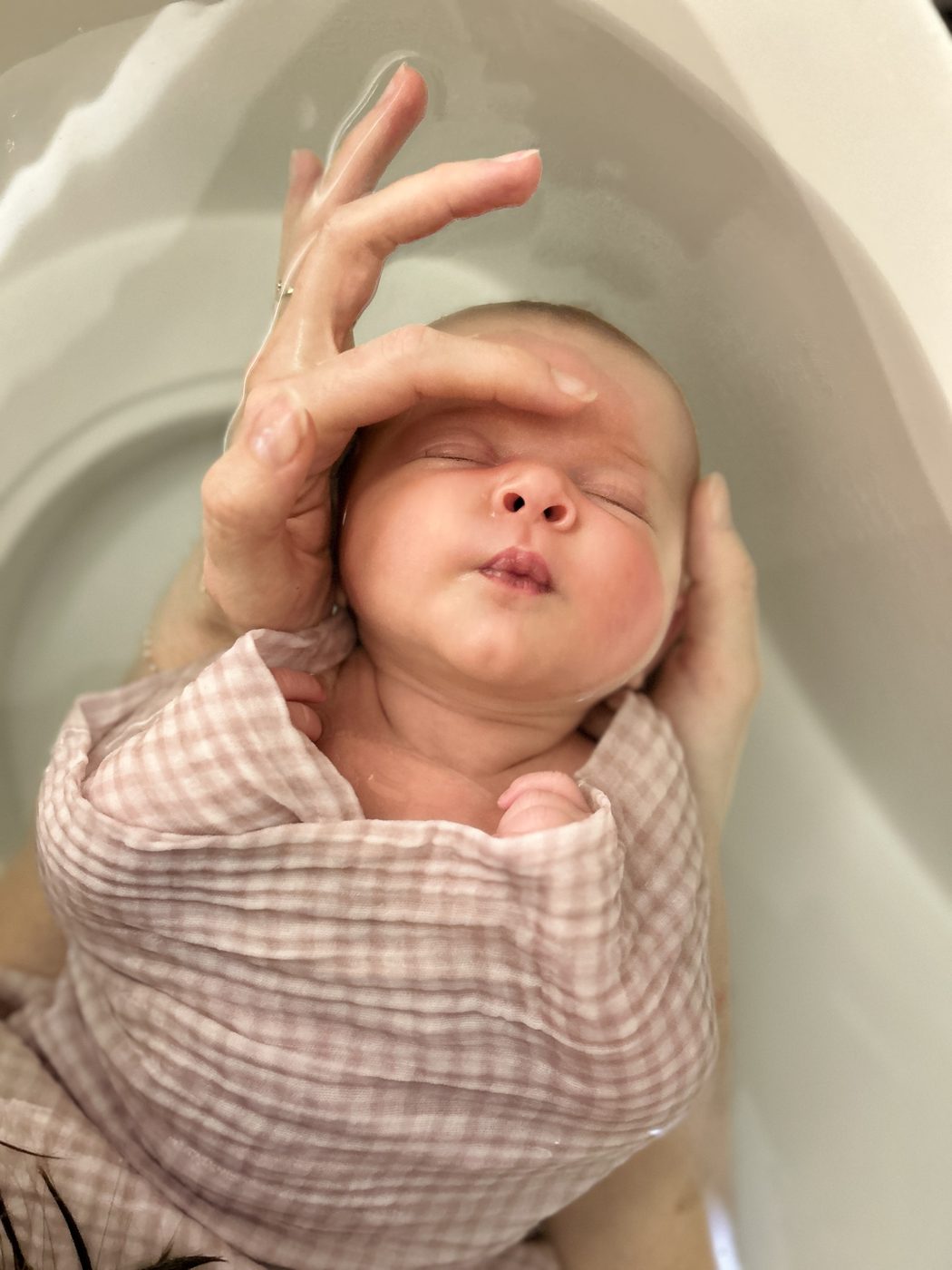 Bébé dans le bain, tenu en toute sécurité