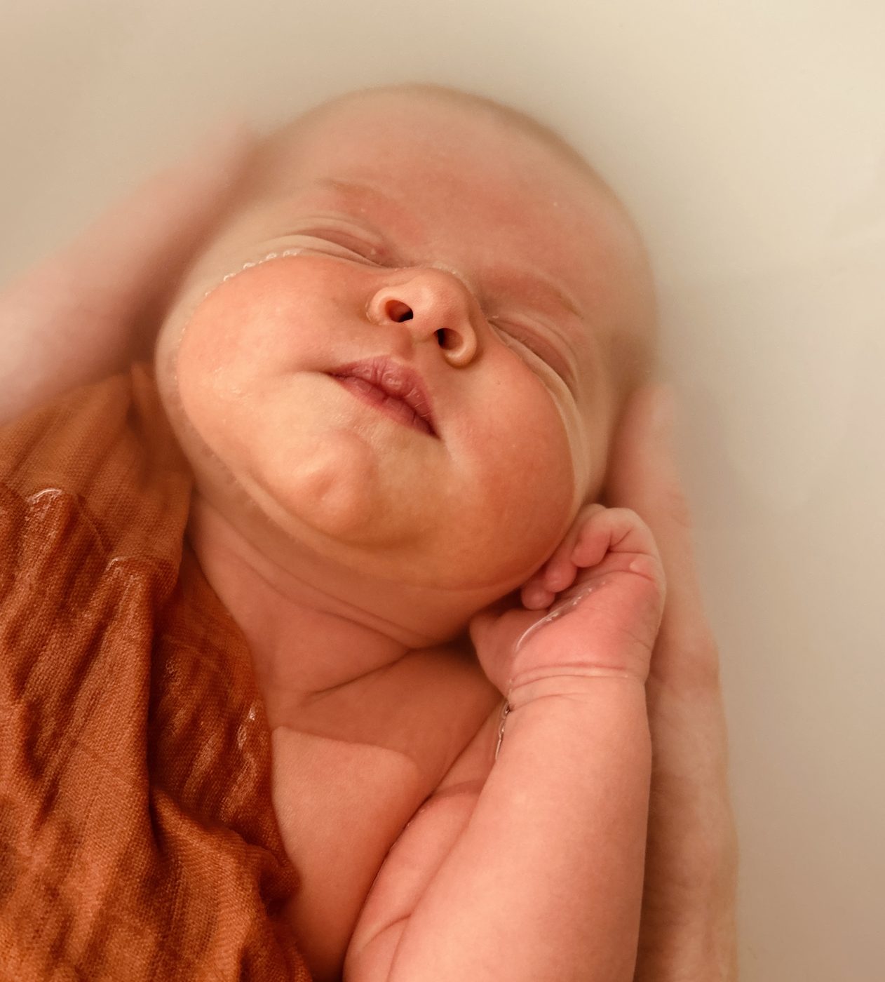 Bébé emmailloté, visage apaisé